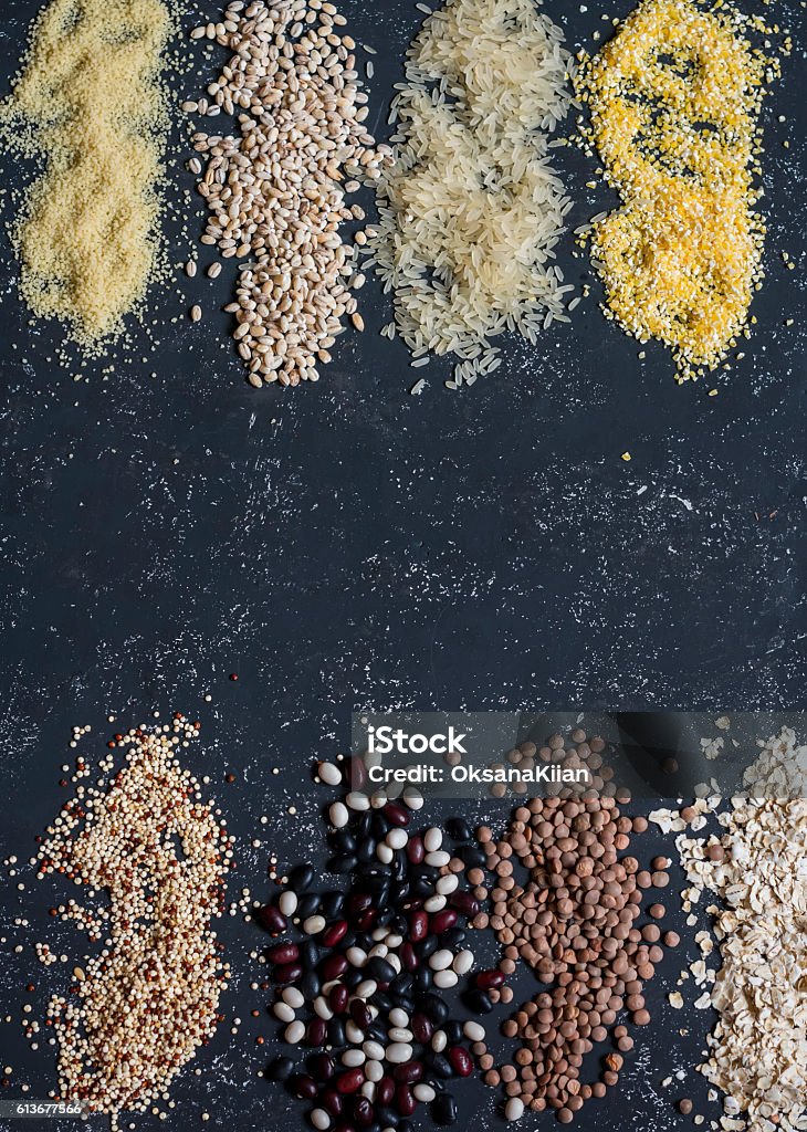 Variation of grain - quinoa, beans, couscous, lentils, barley, oatmeal. Food background. Variation of grain - quinoa, beans, rice, oatmeal, couscous, lentils, barley, oatmeal. On a dark background, top view Above Stock Photo