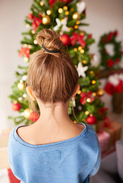 istock Little girl looking at Christmas tree 613679940