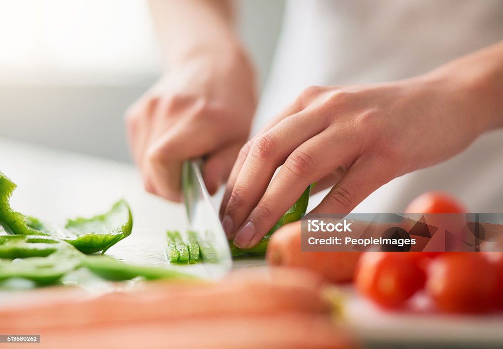 Preparing a wholesome meal filled with organic goodness Closeup shot of a young woman chopping vegetables in the kitchen Vegetable Stock Photo