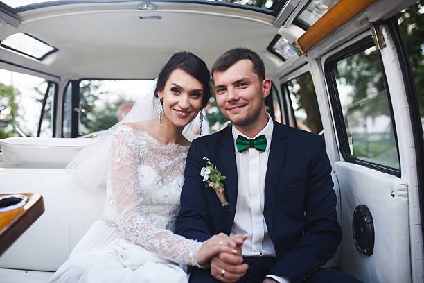 istock bride and groom sitting in the car 613680358
