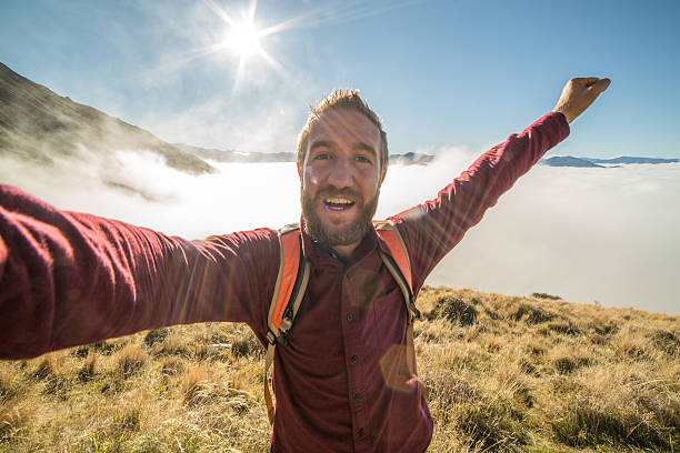 istock Young man capturing successful moment with selfie 613680384