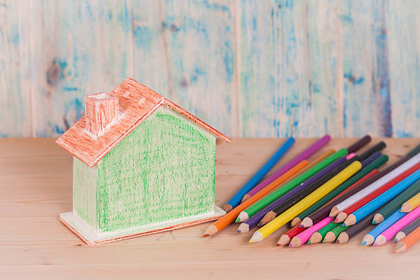 istock miniature model house with color pencil on table 613681128
