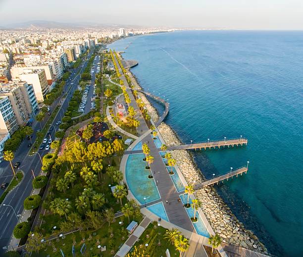 Aerial view of Molos, Limassol, Cyprus Aerial view of Molos Promenade on the coast of Limassol city in Cyprus. A view of the walk path surrounded by palm trees, pools of water, grass, the Mediterranean sea, piers, rocks and urban skyline. limassol stock pictures, royalty-free photos & images