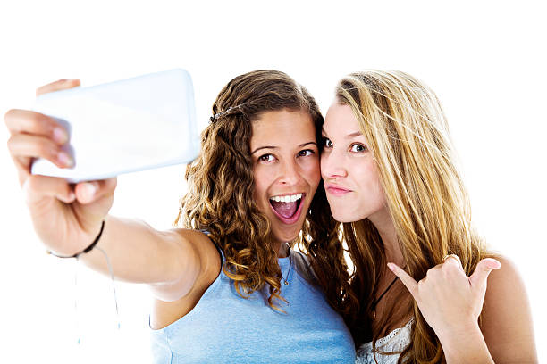 istock Two cute young young women take silly, smiling Selfies 613682476
