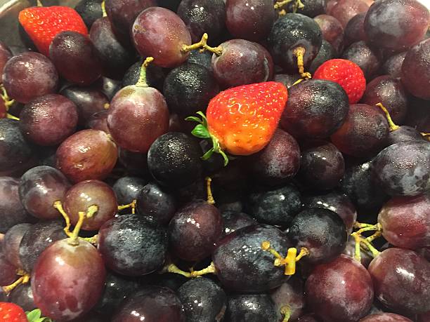 istock Cluster of red grapes and strawberries 613683152