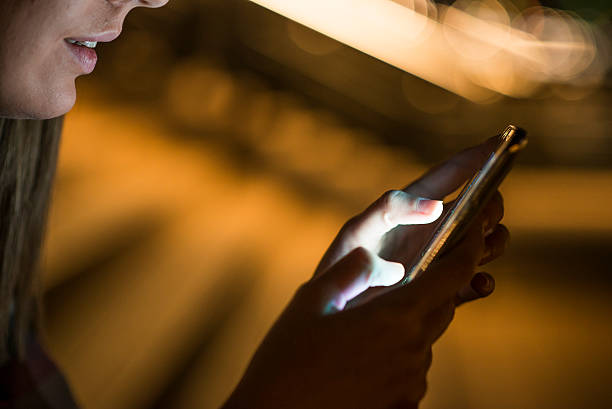 istock Woman using her smart phone , city skyline night light backgroun 613683748