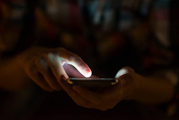 istock Woman using her mobile phone, city skyline night light backgroun 613683864