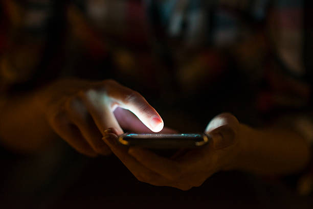 istock Woman using her mobile phone, city skyline night light backgroun 613683936