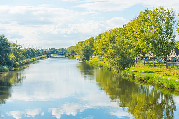 istock Shore of a canal in sunlight at fall 613685960