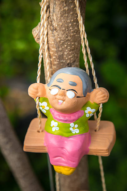 istock old man happy swing doll in the park 613686152