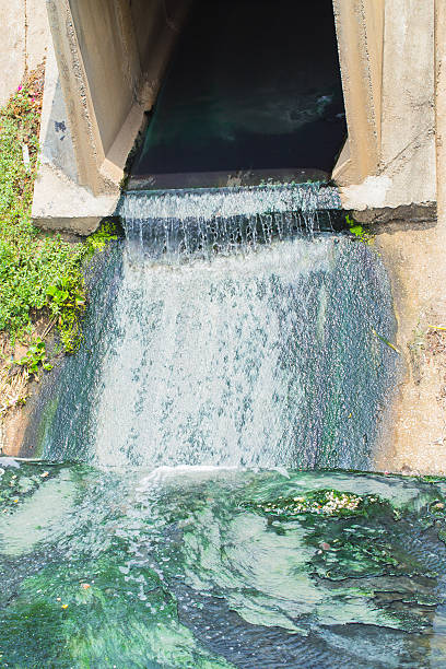 istock Sewer drain pipe of waste water flow to river 613686518