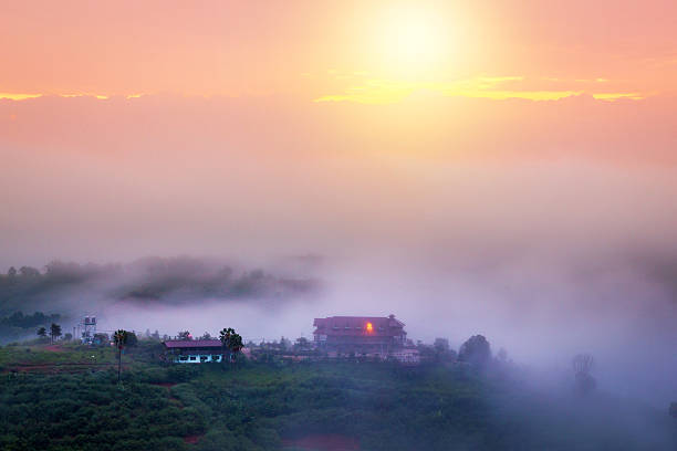 soft focus Sunny sunrise in a beautiful countryside. Gentle fog above village church. Warm sun light with cold ground mist in valley.