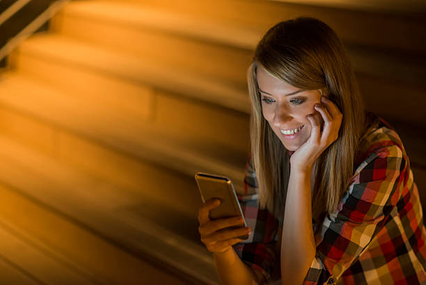 istock Delighted  woman reading an sms on her mobile phone smiling 613688144