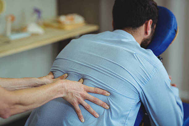 istock Physiotherapist giving back massage to a patient 613688394