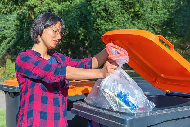 Photo of Dutch woman throwing plastic garbage in thrash bin