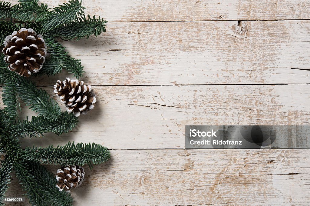 Winter background Top view of fir branch and snowy pine cones on white rustic table. High angle view of christmas fir tree on  wooden board with copy space. Winter frame with coniferous branches. Table Stock Photo