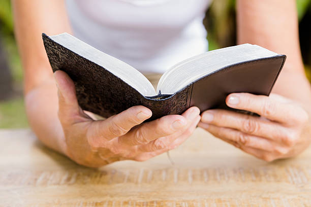 istock Midsection of woman reading bible 613690238