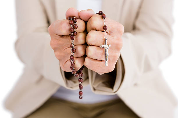 istock Woman holding rosary beads 613690276