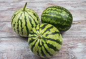 Three small watermelons on wooden background
