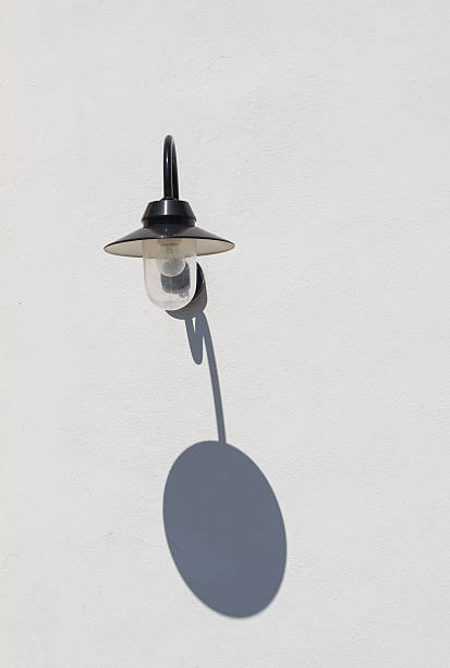 istock Street wall lamp and its shadow 613693118
