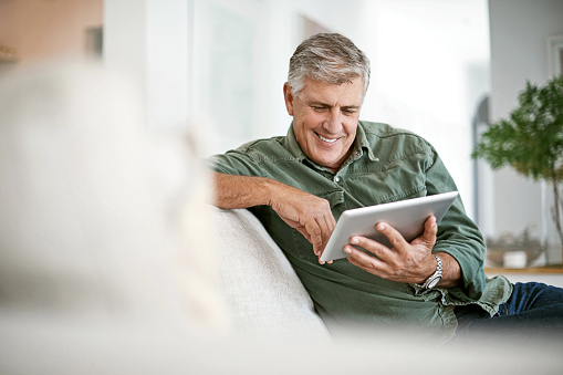 Cropped shot of a mature man using a digital tablet at home