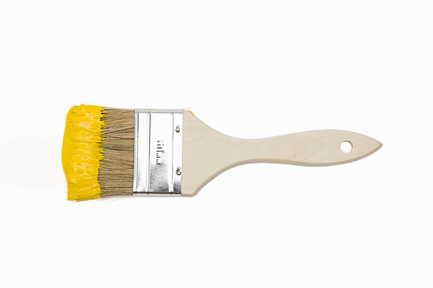 Paintbrush with yellow paint isolated on white