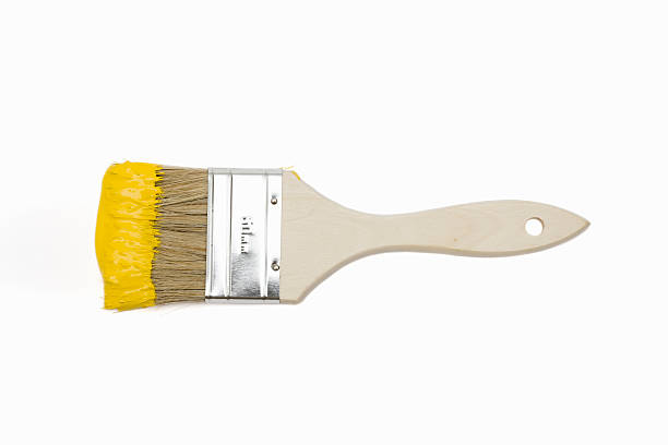 Paintbrush with yellow paint Paintbrush with yellow paint isolated on white brush stock pictures, royalty-free photos & images