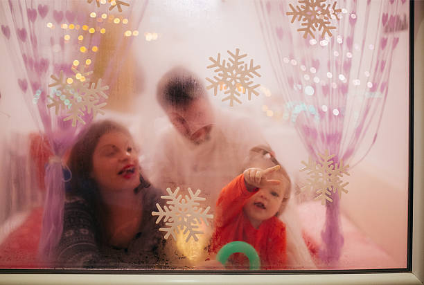 istock Family behind the window on Christmas Night 613695786