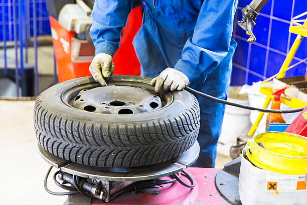 istock Auto mechanic is changin tire...prepairing car for winter 613747664