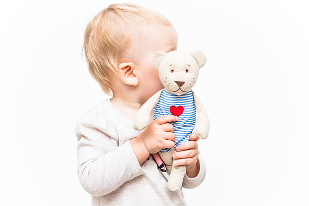 Baby girl with a teddy bear. Studio shot on the white background