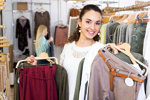 istock Cheerful female customer selecting new garments 613754612