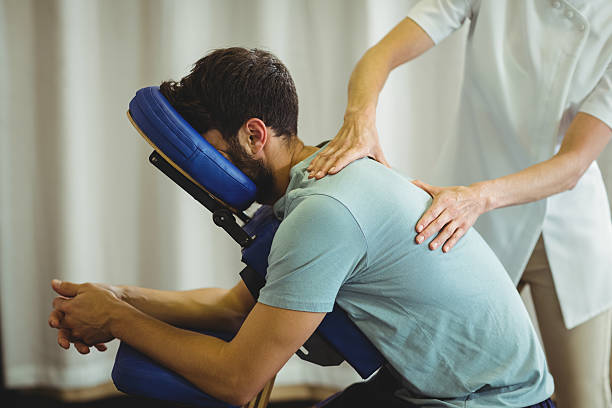 physiotherapeut gibt einem patienten eine massage zurück - backache massaging pain back stock-fotos und bilder