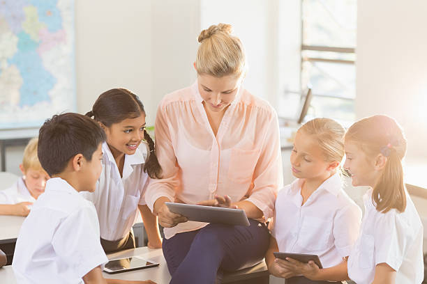 istock Teacher teaching kids on digital tablet 613758998