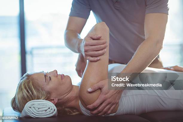 Donna Che Riceve La Terapia Della Spalla Dal Fisioterapista - Fotografie stock e altre immagini di Fare lo stretching