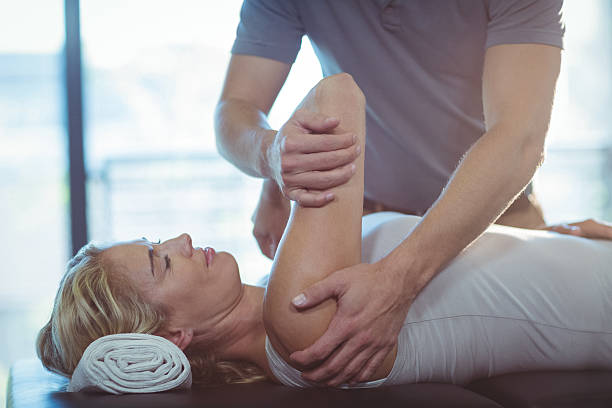 Woman receiving shoulder therapy from physiotherapist Woman receiving shoulder therapy from physiotherapist in clinic physical therapy stretching stock pictures, royalty-free photos & images