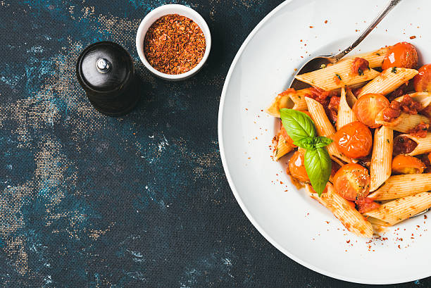 istock Pasta penne with tomato sauce, basil, roasted tomatoes. Copy space 613761276