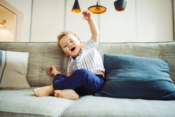 ソファで遊ぶ少年 - domestic life jumping child sofa ストックフォトと画像