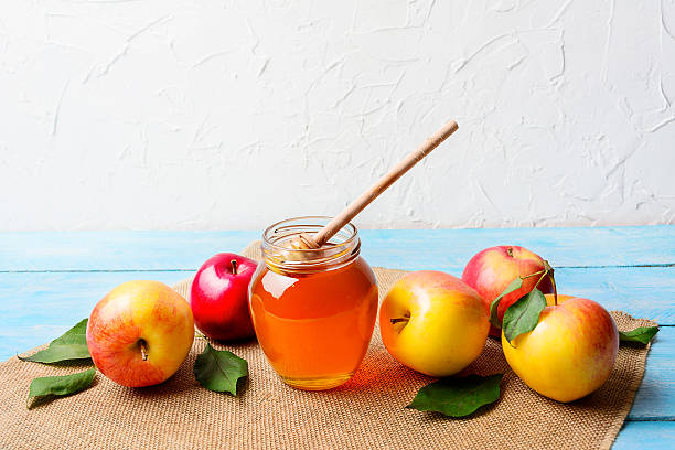 istock Glass honey jar with dipper and apples copy space 613762088