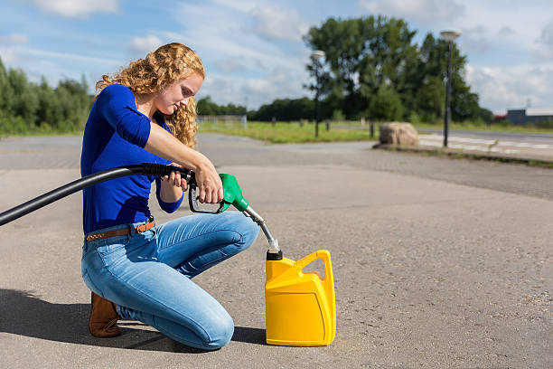 donna olandese che alimenta jerrycan con tubo benzina - gasoline fuel pump women currency foto e immagini stock