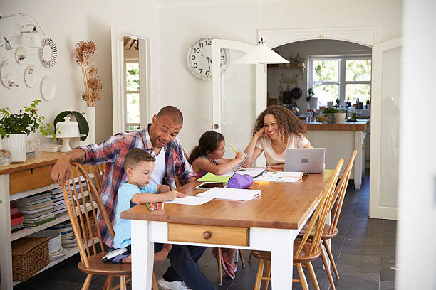 istock Parents Helping Children With Homework At Table 613765036