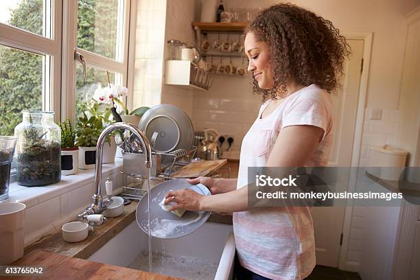 Woman Standing At Kitchen Sink Washing Up Stock Photo - Download Image Now - Washing Dishes, Washing, Women