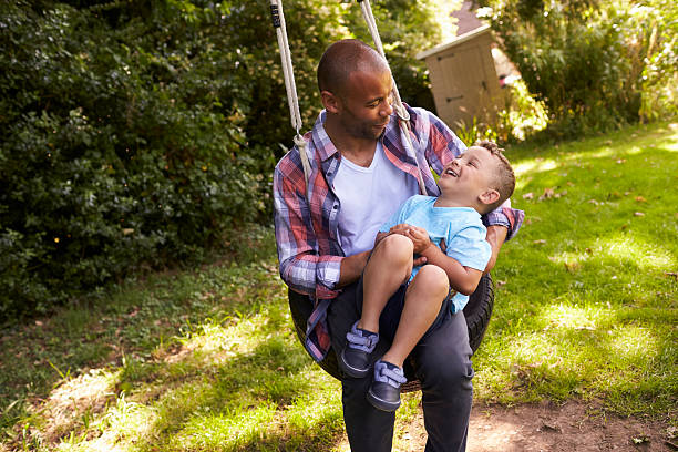 istock Father And Son Having Fun On Tire Swing In Garden 613765280