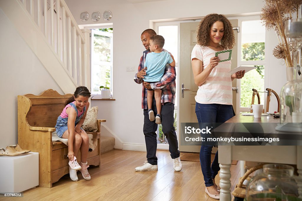 Family In Hallway Returning Home Together Mail Stock Photo