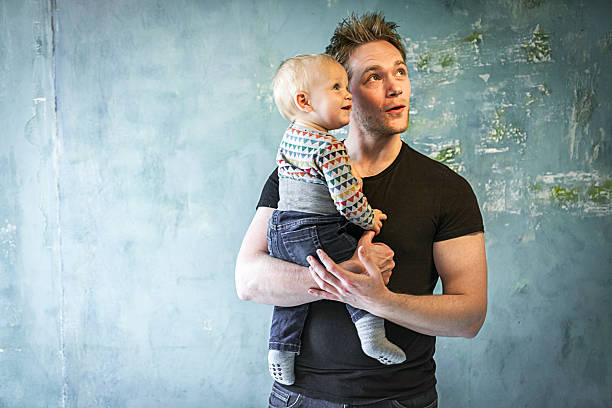 Happy young father and baby looking up