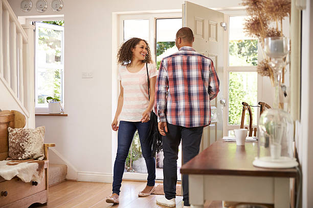 istock Man Opens Front Door For Woman Returning Home From Work 613765398