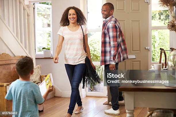 Father Opens Front Door For Mother Returning Home From Work Stock Photo - Download Image Now