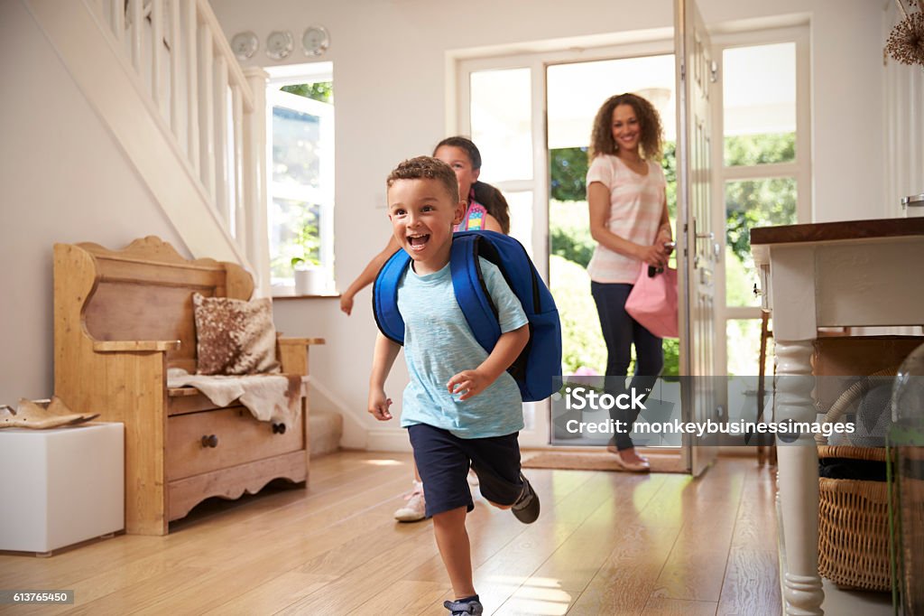 Excited Children Returning Home From School With Mother Arrival Stock Photo