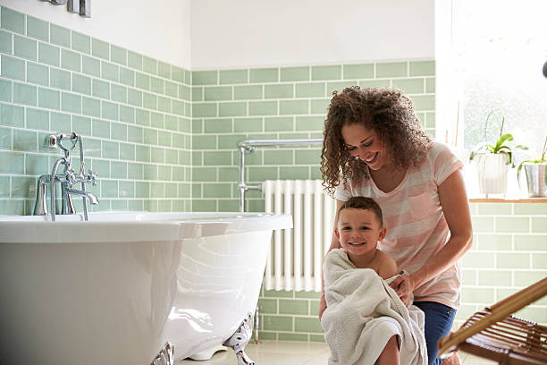 madre secando hijo con toalla después del baño - bañera fotografías e imágenes de stock