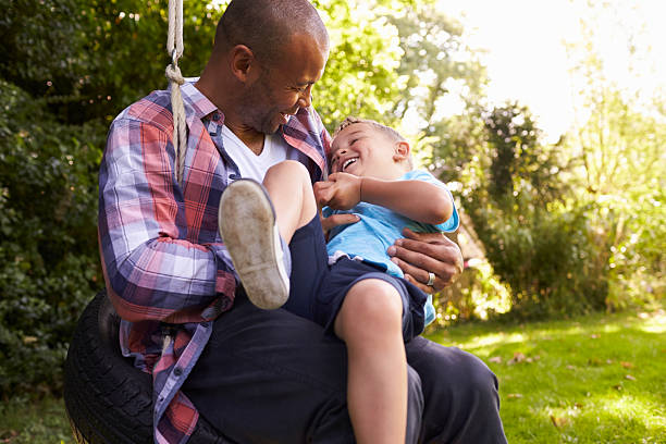 istock Father And Son Having Fun On Tire Swing In Garden 613765760