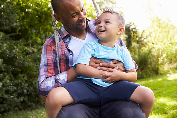 istock Father And Son Having Fun On Tire Swing In Garden 613765782